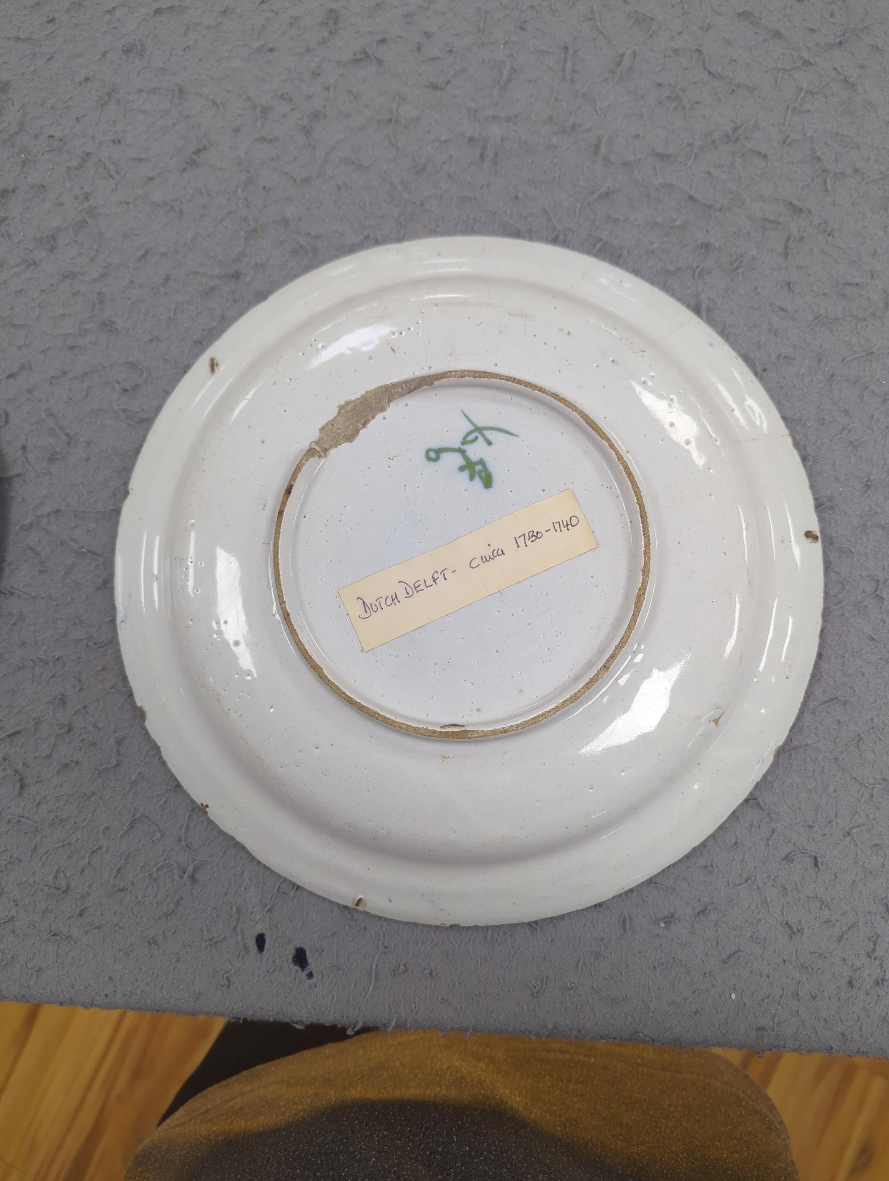 An 18th century Delft plate and three 19th century faience plates, largest 26cm diameter (4)